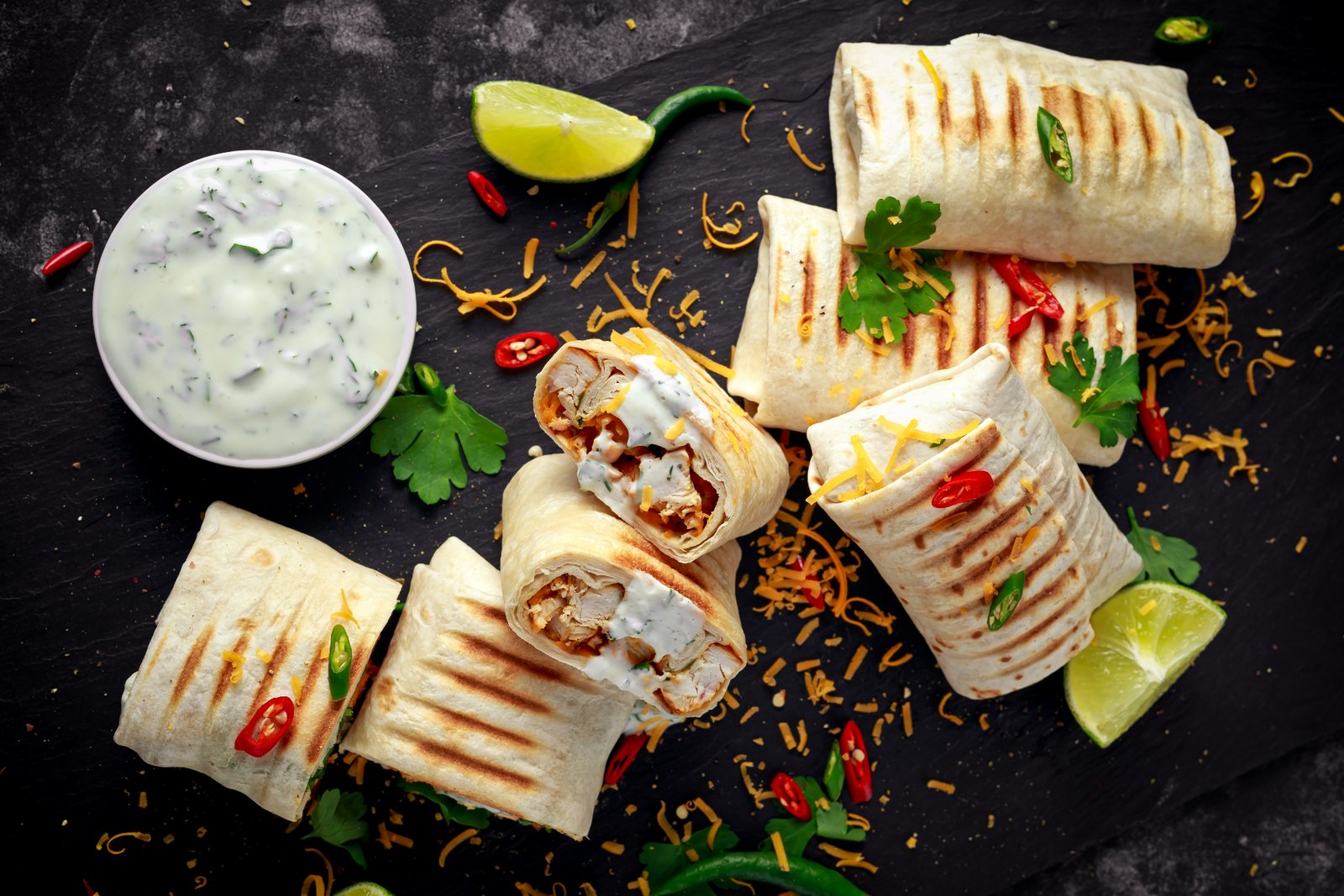 Loaded Tex-Mex grain bowl next to a grilled burrito cut in half